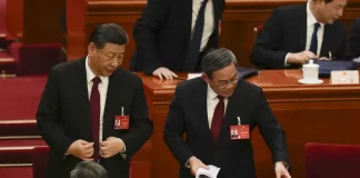 Chinese President Xi Jinping left, listens to Chinese Premier Li Qiang after the opening session of the national peoples congress (NPC) at the Great Hall of the People in Beijing, China