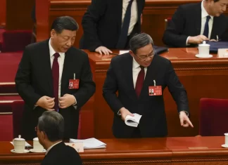 Chinese President Xi Jinping left, listens to Chinese Premier Li Qiang after the opening session of the national peoples congress (NPC) at the Great Hall of the People in Beijing, China